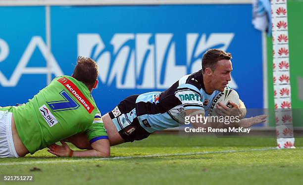 James Maloney of the Sharks scores a try in the tackle of Aidan Sezer during the round seven NRL match between the Canberra Raiders and the Cronulla...