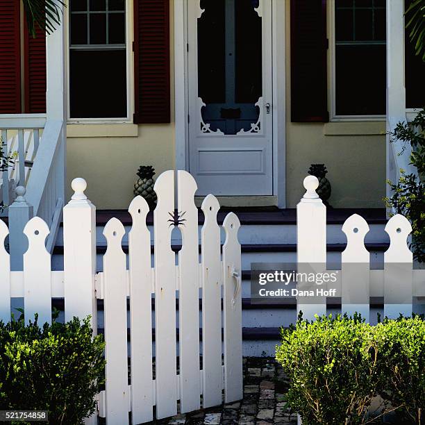white picket fence in front of porch with red shutters on windows - white picket gate stock pictures, royalty-free photos & images