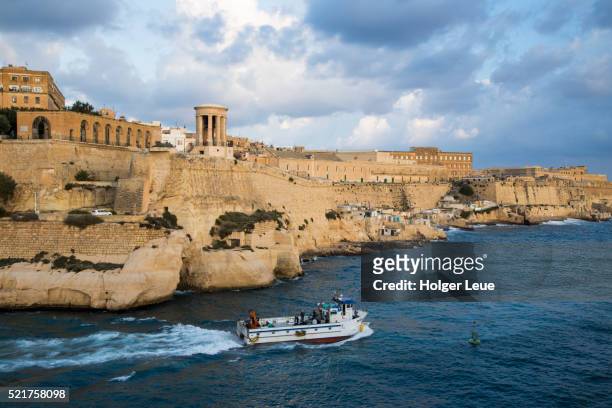 siege bell war memorial and abercrombie's bastion seen from grand harbor entrance - malta harbour stock pictures, royalty-free photos & images