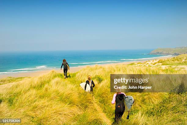 surfers heading down to perran bay - cornwall engeland stockfoto's en -beelden