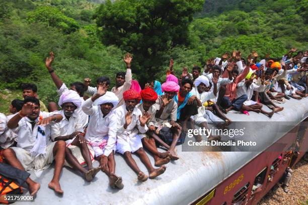 people taking risk while travelling on roof of train, goram ghat, marwar junction, rajasthan, india - brockenbahn stock-fotos und bilder