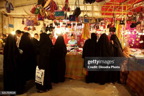 muslim women doing their last minute id or festive shopping at the local market of malegaon, maharashtra, india - burqa for sale stock pictures, royalty-free photos & images