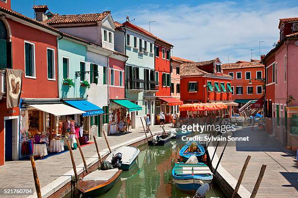 colorful boats and homes lining canal in burano, venice - burano fotografías e imágenes de stock