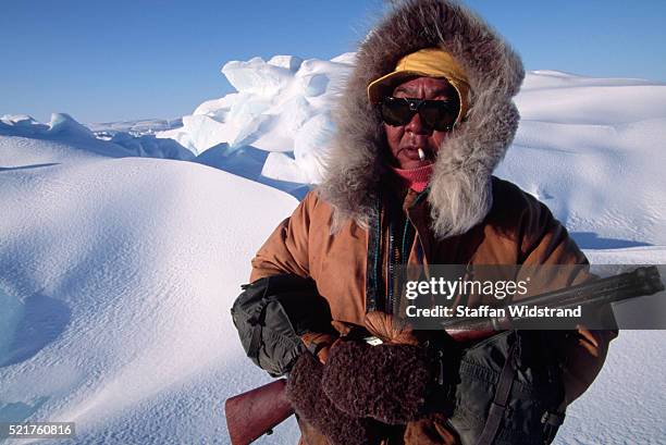 inuit seal hunter holding a rifle - nunavut stock-fotos und bilder