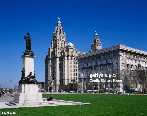 statue in front of royal liver building and cunard building in liverpool - royal liver building stock pictures, royalty-free photos & images
