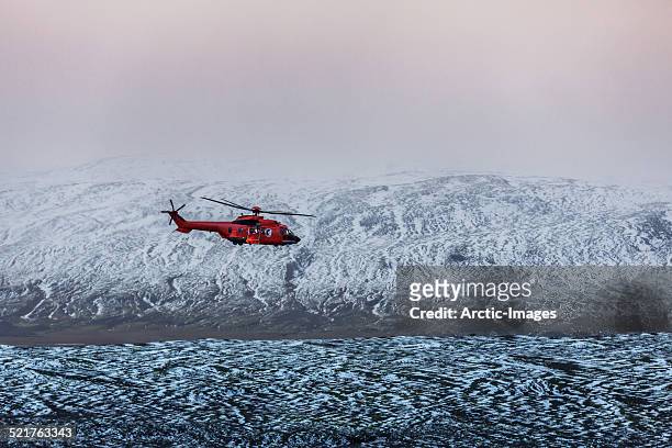 helicopter flying, snow covered landscape, iceland - helicopter rescue stock pictures, royalty-free photos & images