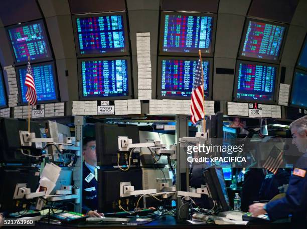 traders work in front of computers on the floor of the new york stock exchange. - us stock exchange trading floor stock pictures, royalty-free photos & images
