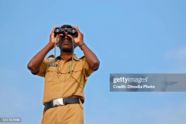 policeman keeping watch through binocular - indian police officer image with uniform stock-fotos und bilder