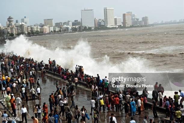 people enjoying hightide waves at marine drive, bombay, mumbai, maharashtra, india - high tide in mumbai stock pictures, royalty-free photos & images