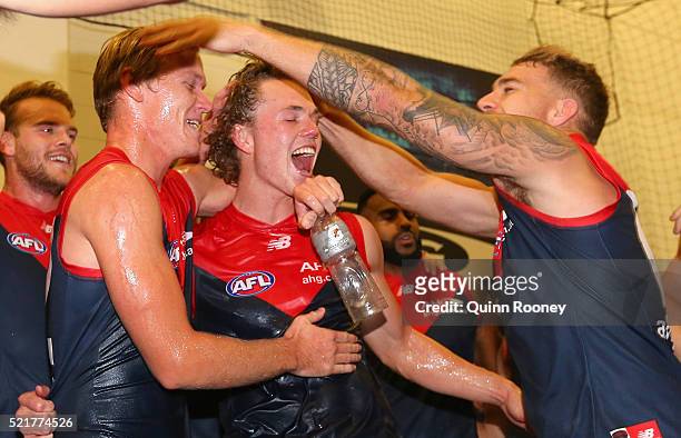 Josh Wagner and Jayden Hunt of the Demons are congratulated by Dean Kent as the Demons celebrate winning the round four AFL match between the...