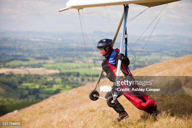 a hang glider flying from the side of pendle hill, above clitheroe in lancashire, uk. - england captains run stock pictures, royalty-free photos & images