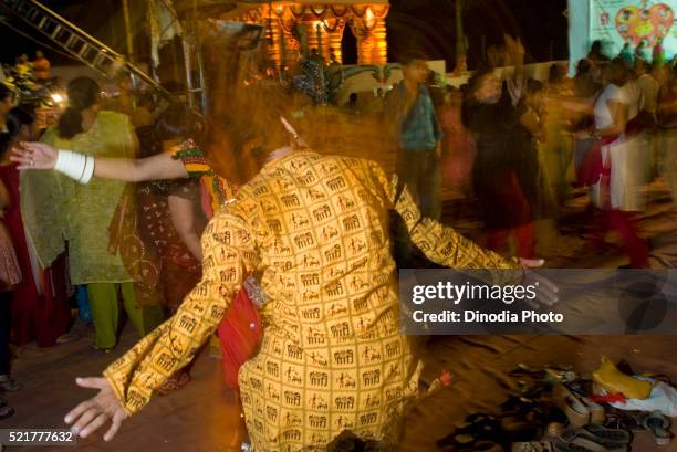 man wearing kurta with tribal motifs playing garba during festival of navaratri, borivali, bombay mumbai - navratri festival celebrations stockfoto's en -beelden