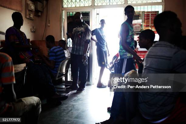 Young men work on computers in an Internet café on April 17, 2015 in Zongo Area in central Accra, Ghana. They work on Romance scams, credit card...