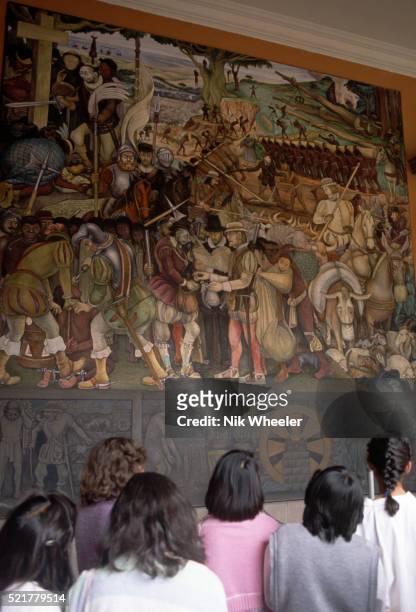 Visitors view "Mexico Through the Centuries", by Diego Rivera, on a staircase of the National Palace in Mexico City. | Located in: Palacio Nacional,...