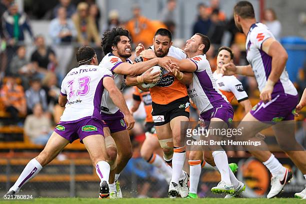 Dene Halatau of the Tigers is tackled during the round seven NRL match between the Wests Tigers and the Melbourne Storm at Leichhardt Oval on April...
