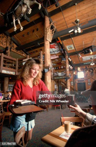 Waitress serves a beer to a patron inside the Mangy Moose Bar near the Teton Village Ski Resort.