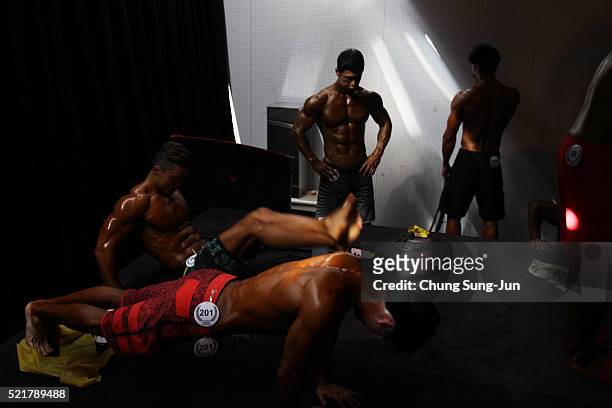Bodybuilders prepare for judging backstage during the NABBA/WFF Asia-Seoul Open Championship on April 17, 2016 in Seoul, South Korea.
