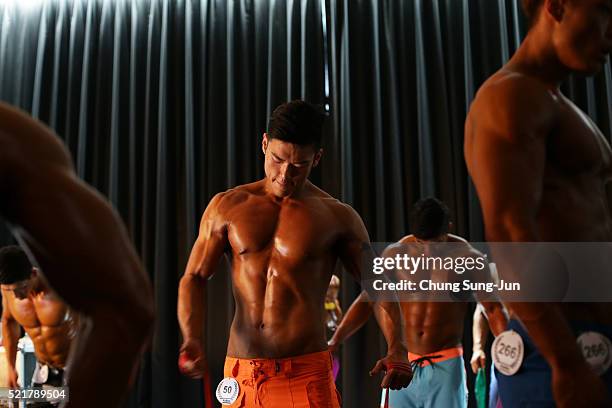 Bodybuilders prepare for judging backstage during the NABBA/WFF Asia-Seoul Open Championship on April 17, 2016 in Seoul, South Korea.