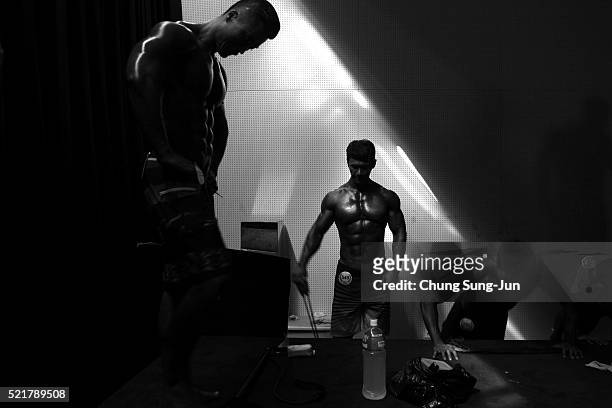 Bodybuilders prepare themselves for judging backstage during the NABBA/WFF Asia-Seoul Open Championship on April 17, 2016 in Seoul, South Korea.