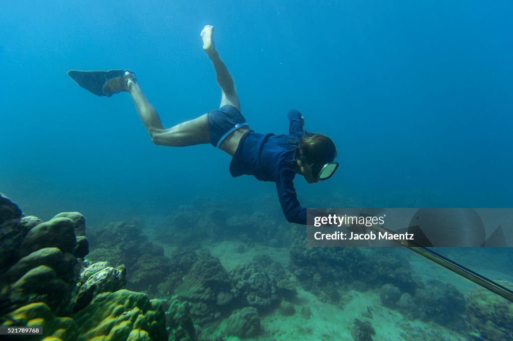 Badjao man spearfishing on coral reef