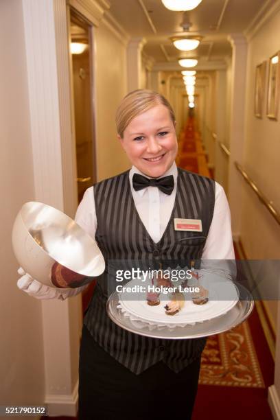 friendly butler with canapes aboard cruise ship ms deutschland (reederei peter deilmann) - ms deutschland cruise ship stock-fotos und bilder