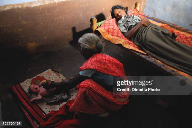 ho tribes midwife cleaning baby, chakradharpur, jharkhand, india - chakradharpur stock pictures, royalty-free photos & images