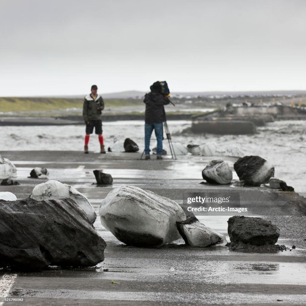 Photographing flooded bridge, boulders of ice, Jokulhlaup (Glacial outburst), Iceland