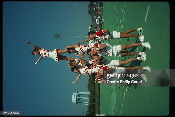 cheerleaders cheering in formation at college football game - vintage cheerleader stock pictures, royalty-free photos & images