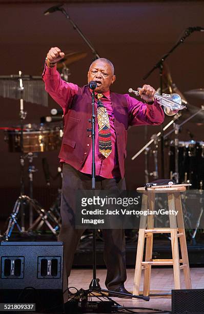 South African composer, bandleader, and musician Hugh Masekela plays fluegelhorn as he performs onstage at the 'Twenty Years of Freedom' concert...