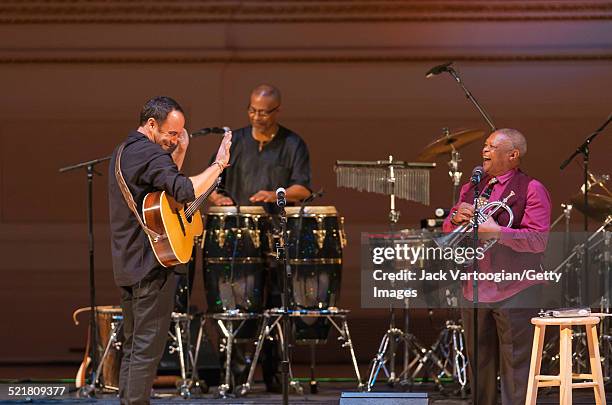 South African-born American musician Dave Matthews plays guitar as a special guest of composer, bandleader, and musician Hugh Masekela onstage at the...