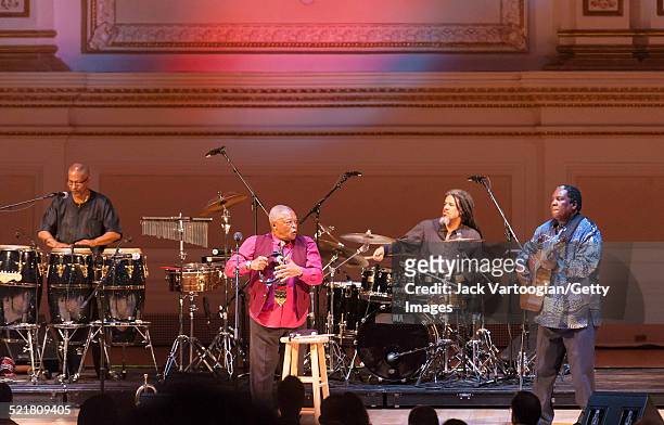 South African composer, bandleader, and musician Hugh Masekela plays fluegelhorn as he leads his band onstage at the 'Twenty Years of Freedom'...