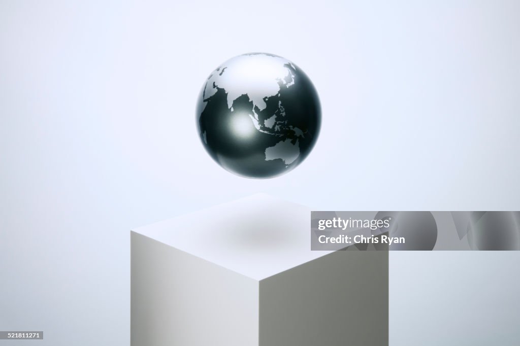 Globe hovering over pedestal