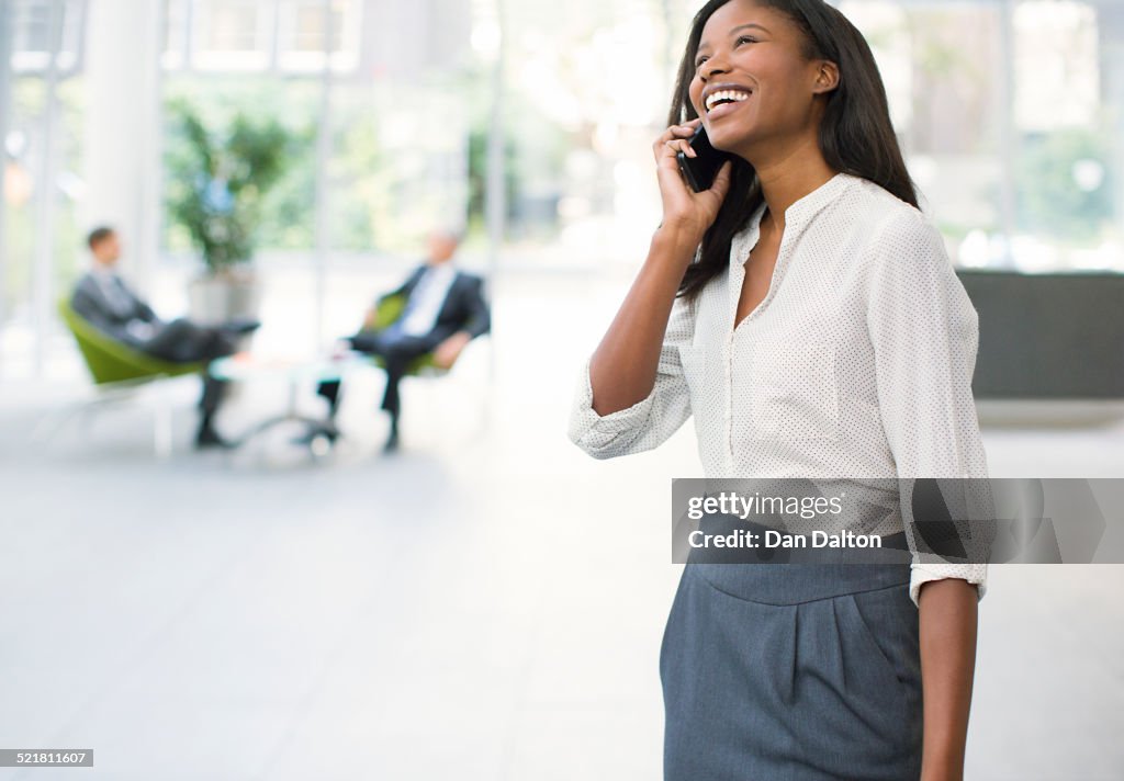 Businesswoman talking on cell phone in office building