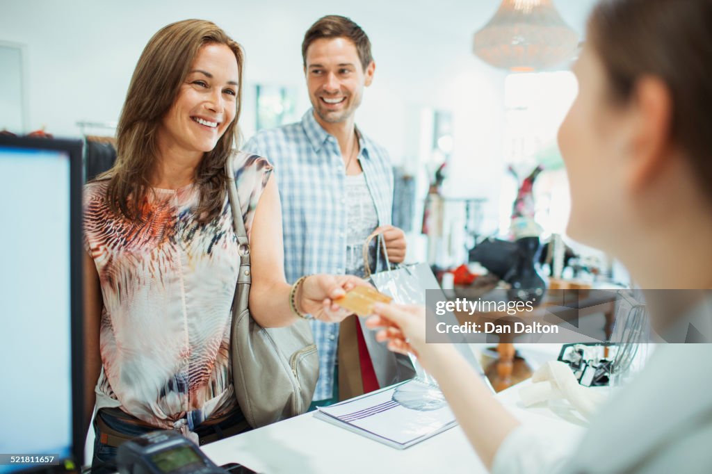 Couple paying with credit card in clothing store