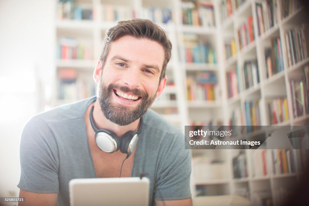 Smiling man using digital tablet in living room