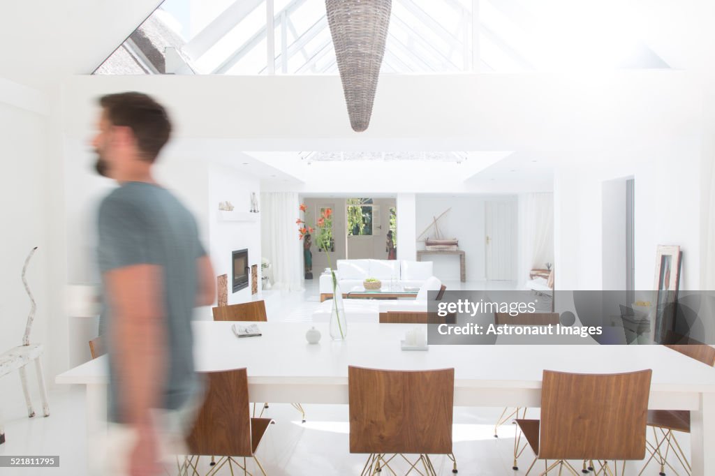 Vista sfocata dell'uomo che cammina nella moderna sala da pranzo