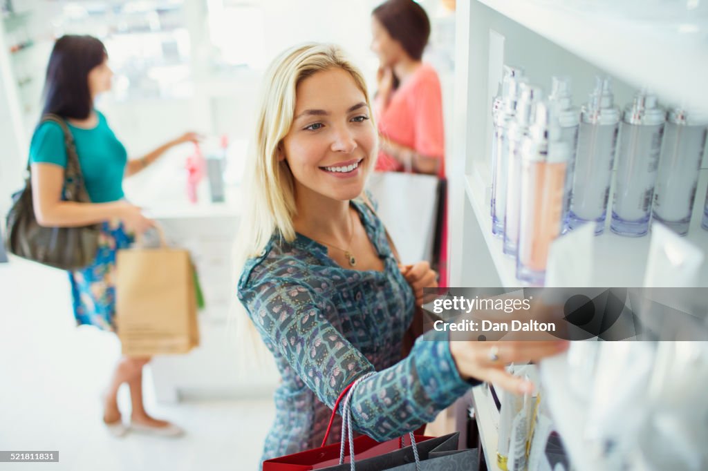 Woman examining skincare products in drugstore