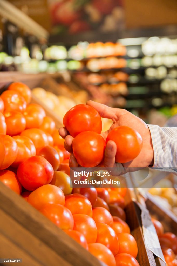 Close up of woman holding fruit in produce section of grocery store