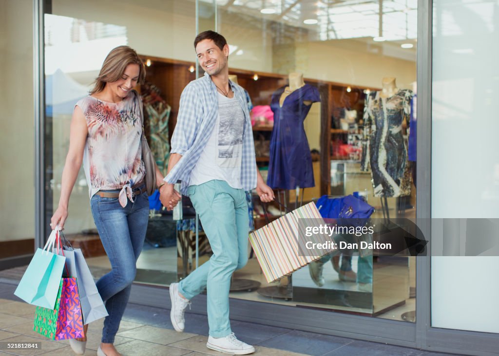 Couple carrying shopping bags in shopping mall