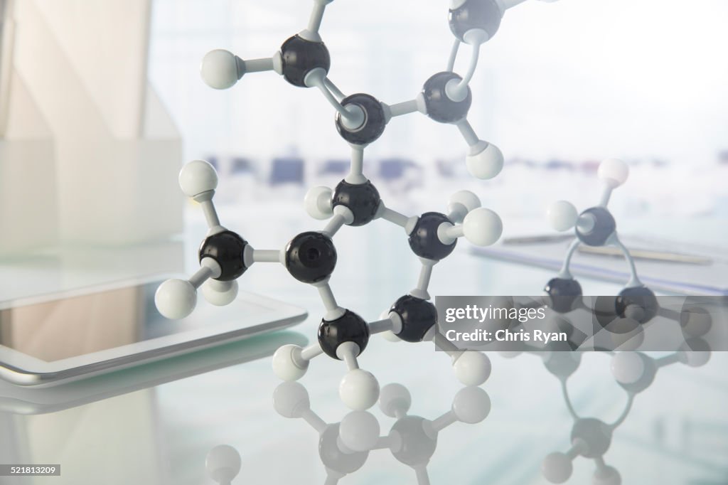 Molecular model and digital tablet on counter in lab