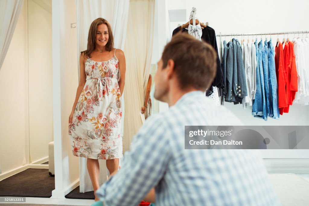 Woman trying on clothes for boyfriend in clothing store