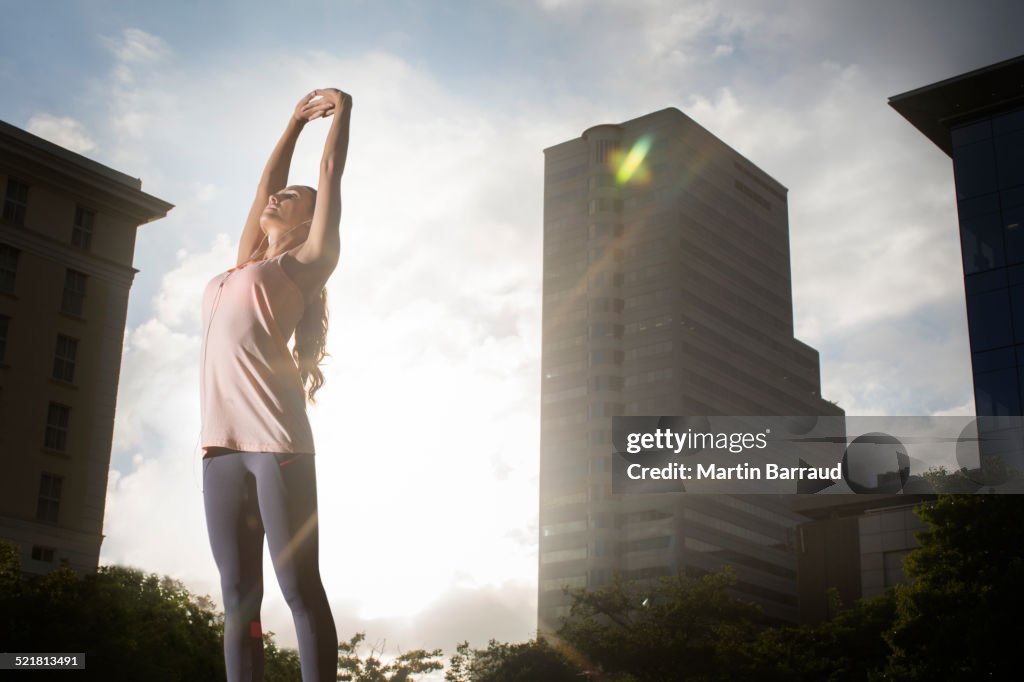 Woman stretching before exercising on city street