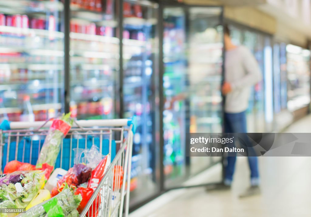 Defocussed view of man shopping in grocery store