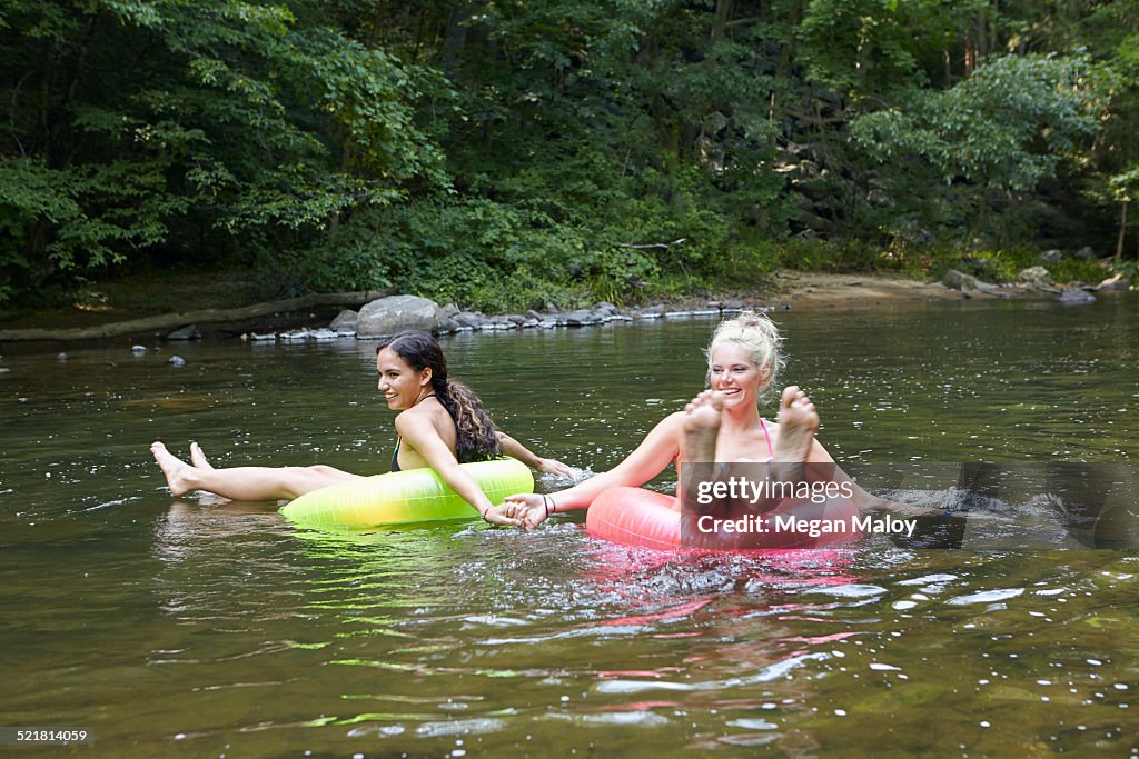 Women in river with inflatable rings
