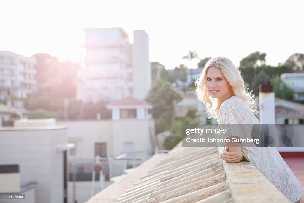 Woman on rooftop, town below in background