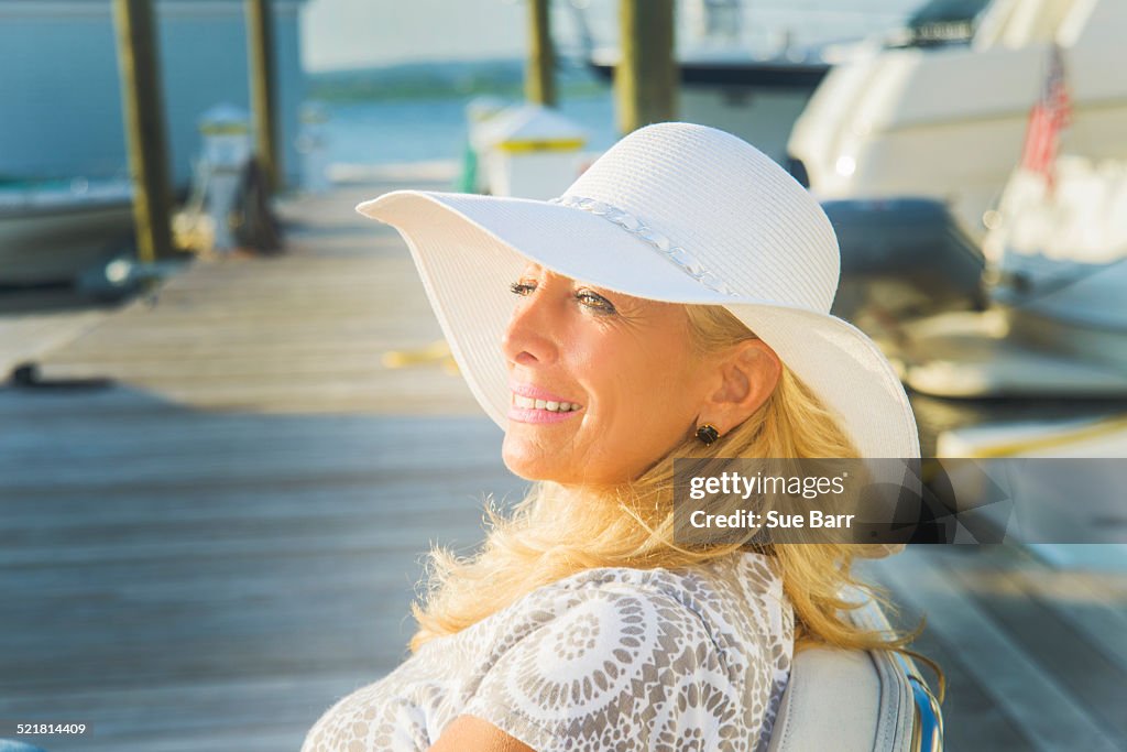 Mature woman sitting on harbor pier, Monmouth Beach, New Jersey, USA