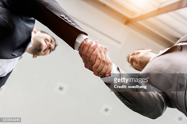 businessmen shaking hands - differential focus fotografías e imágenes de stock