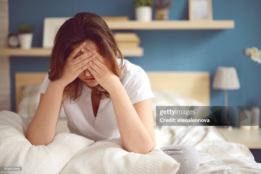 Unhappy girl in a bedroom