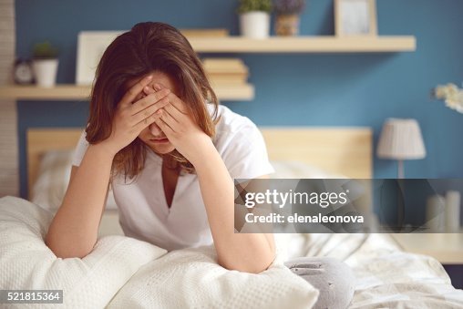 Unhappy girl in a bedroom Unhappy girl in a bedroom