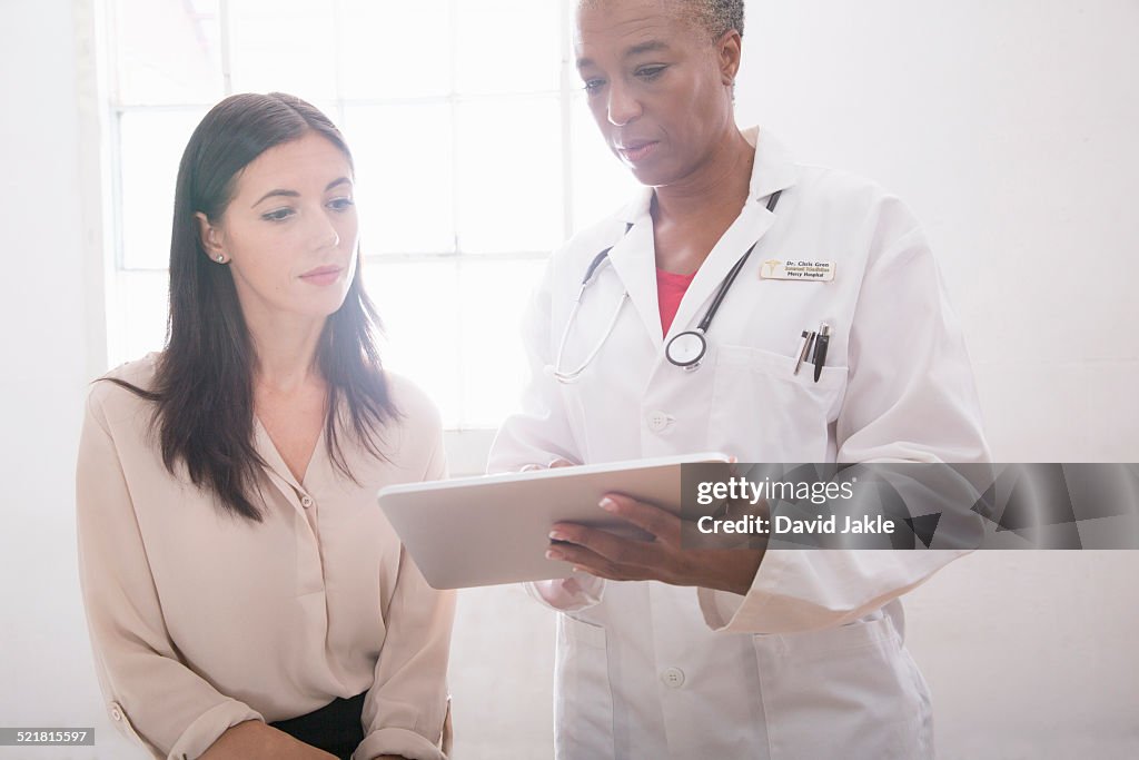 Female doctor using digital tablet in consultation